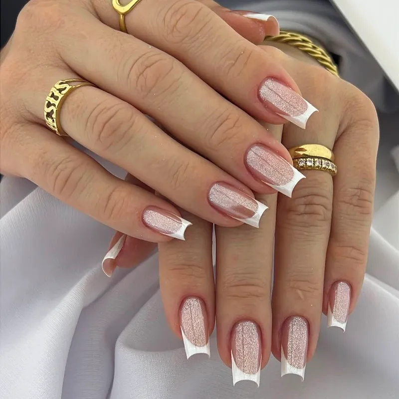 Unhas com francesinha branca sobre base rosa com brilho