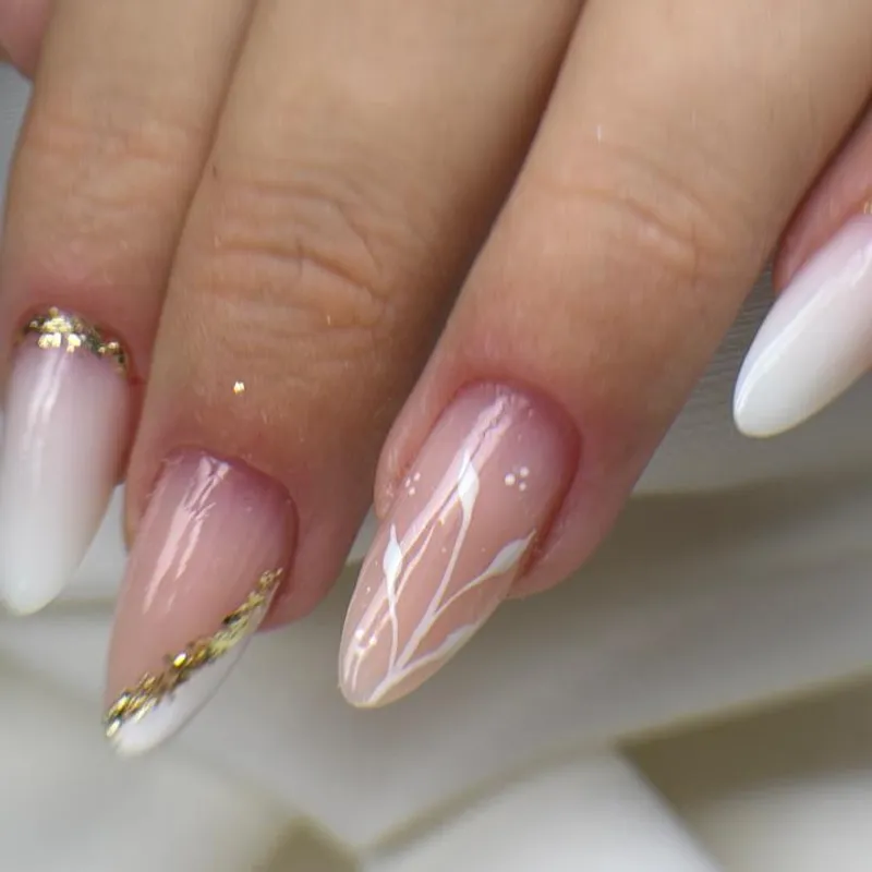 Unhas amendoadas com desenho branco delicado e detalhe em folha dourada
